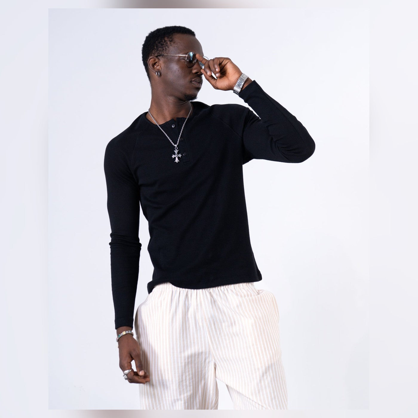 Man wearing the Virgous Classic Rib Black Henley styled with pinstripe trousers