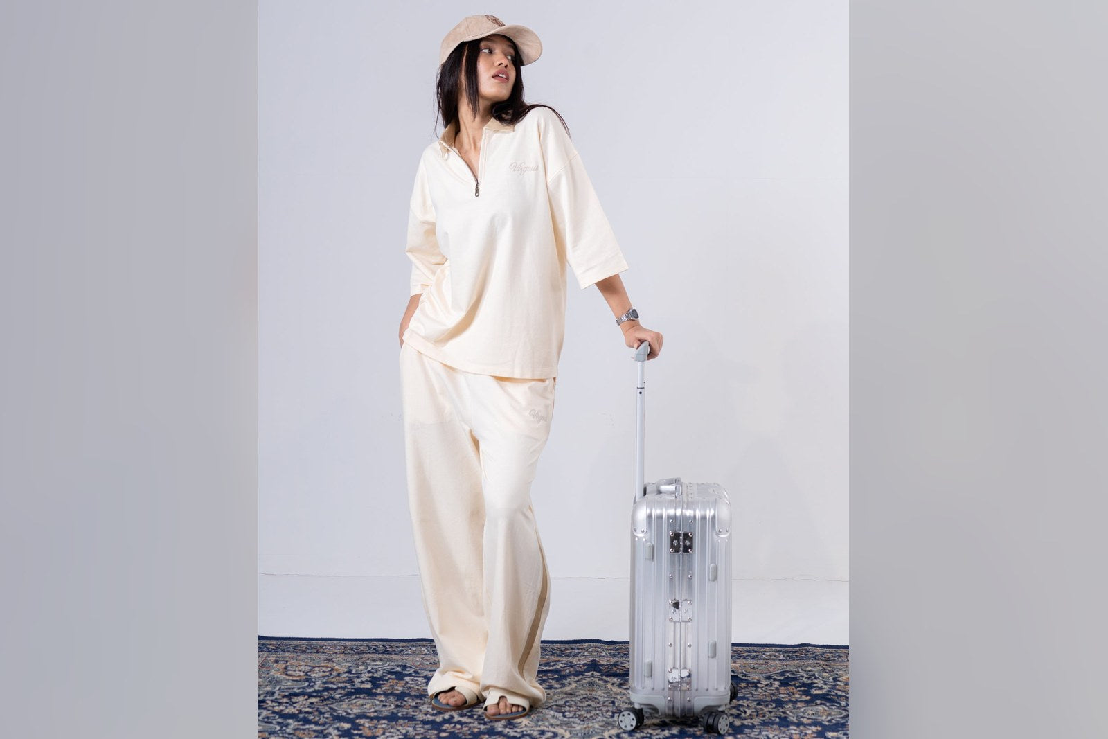 Woman in Virgous ivory co-ord set with a suitcase, airport travel look